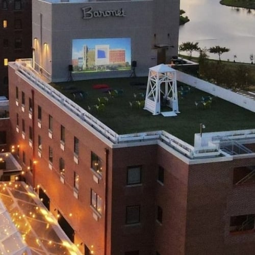The Asbury Hotel, Asbury Park: Vibrant Baronet rooftop cinema, sparkling pool, and welcoming outdoor social areas at dusk.