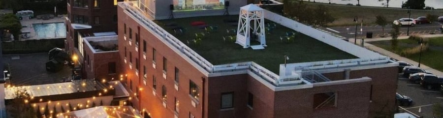 The Asbury Hotel, Asbury Park: Vibrant Baronet rooftop cinema, sparkling pool, and welcoming outdoor social areas at dusk.