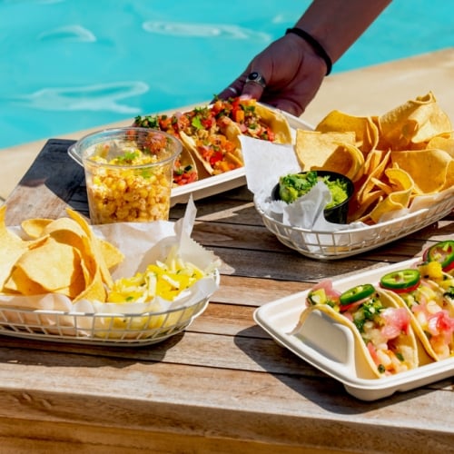 Poolside dining at The Asbury: colorful tacos, chips, and guacamole for a vibrant social gathering in Asbury Park.